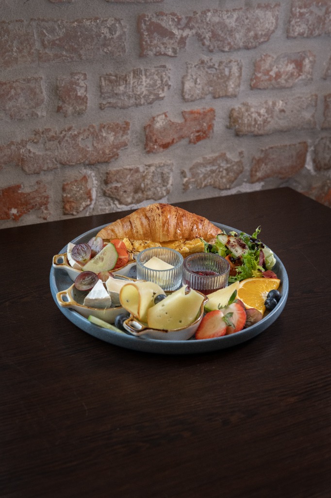 Toastclub Brunch-Platte mit Croissant, Eiern, Käseauswahl und Obst